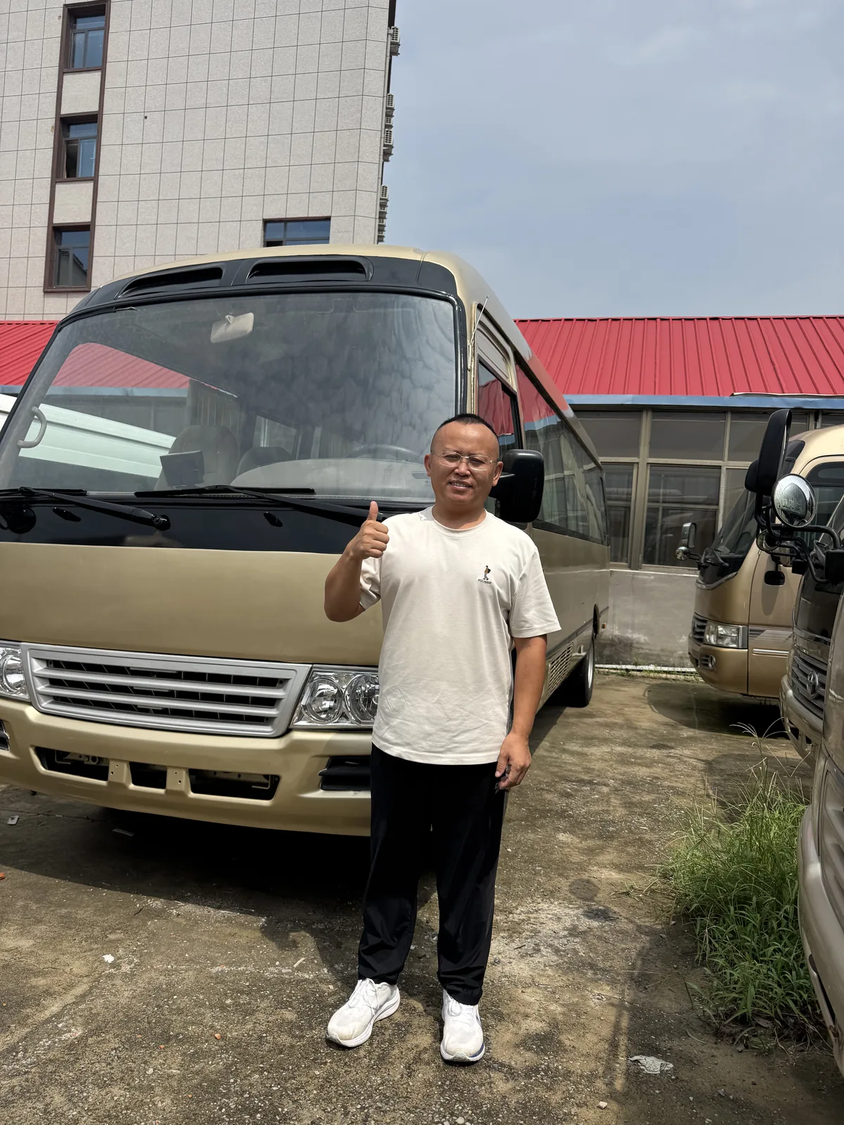 Beige minibus with a man standing beside the vehicle